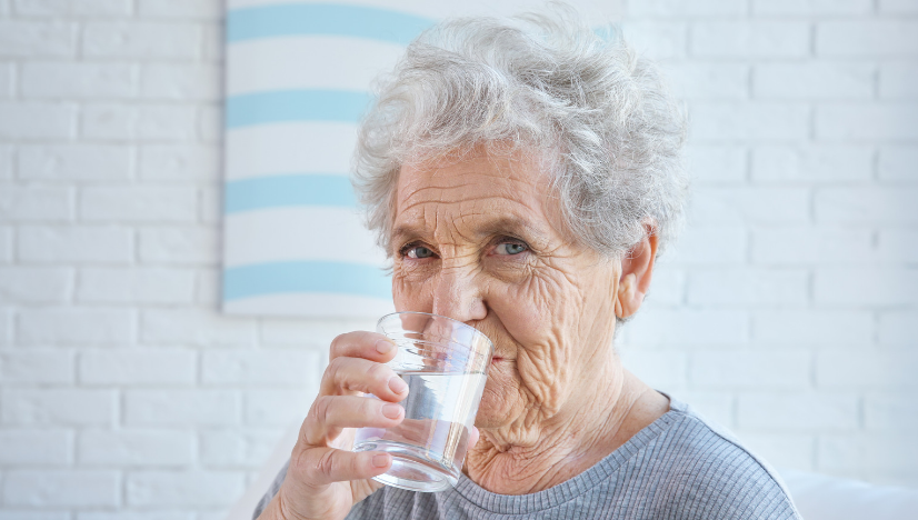 senior drinking a water